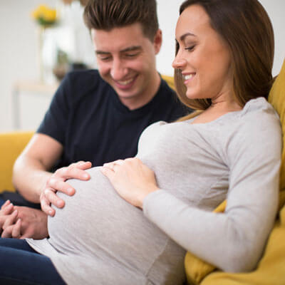Pregnant woman relaxing with her partner on a couch