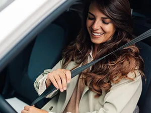 woman in car buckling her seatbelt