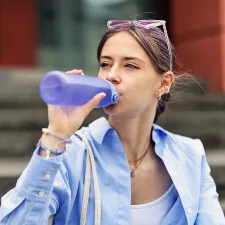 woman drinking from reusable water bottle