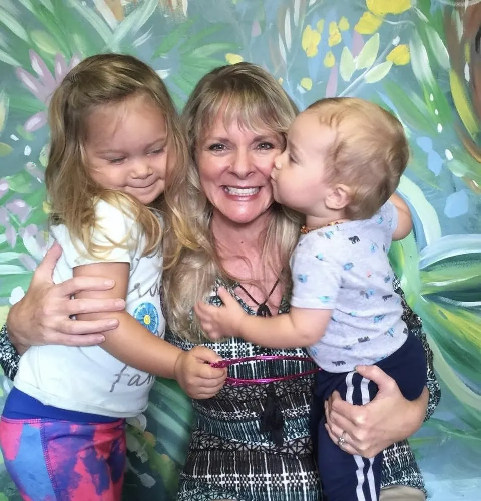 Dr. Anna Saylor hugging two toddlers in the office
