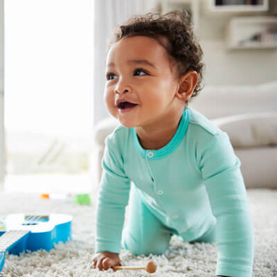 Baby playing happily on the floor at home
