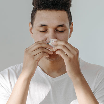 Person holding their sinuses in discomfort from congestion and pressure