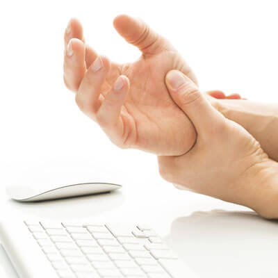 Person holding their wrist, an area often affected by joint and skin tightness in scleroderma