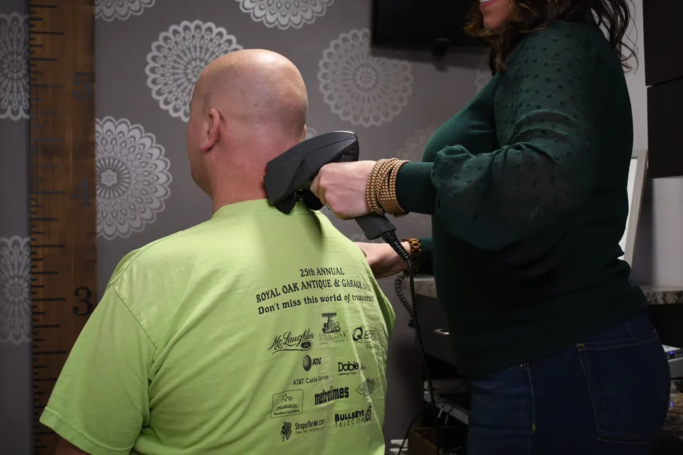 A member of our team running an INSiGHT scan along a patient's neck and spine