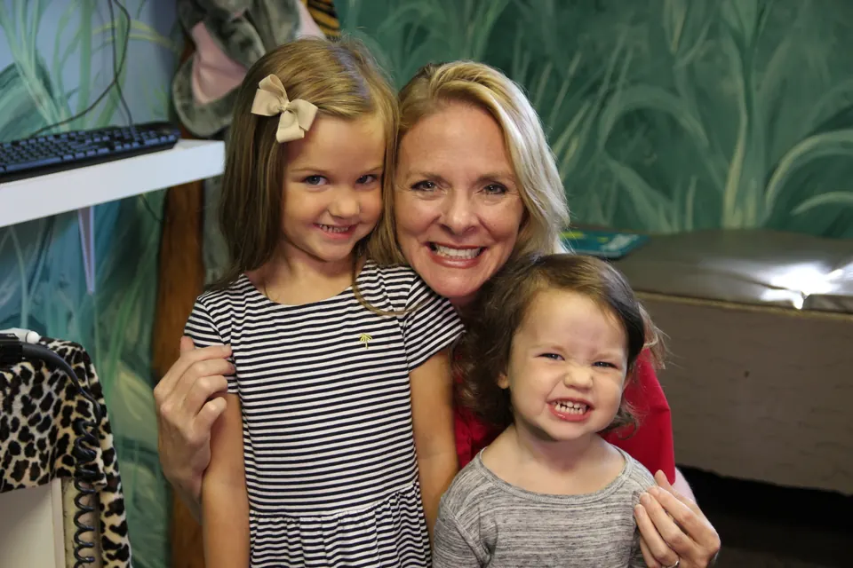 Dr. Anna Saylor laughing with two young girls in our jungle room