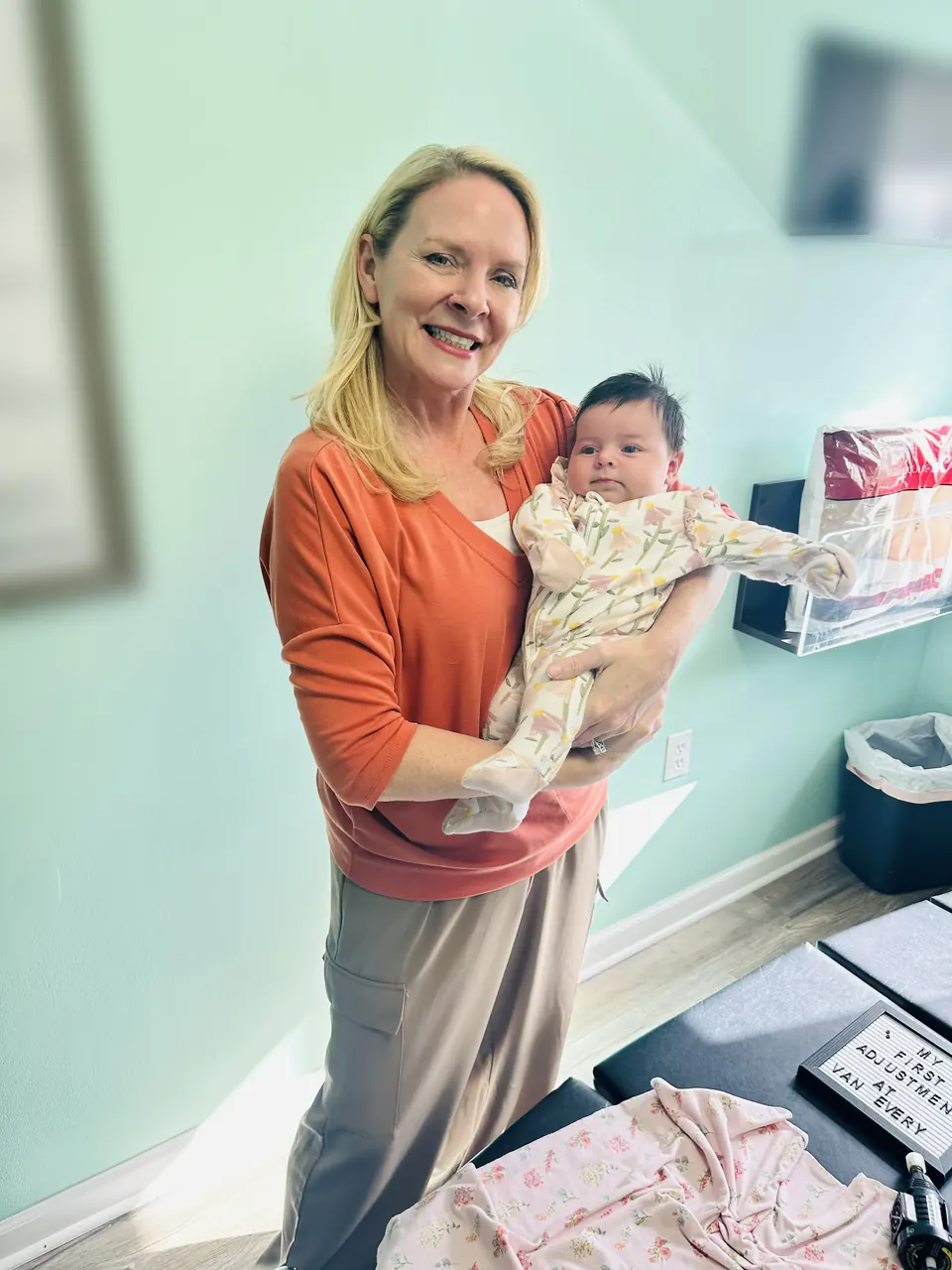 Dr. Anna Saylor smiling as she holds a newborn in one of our treatment rooms