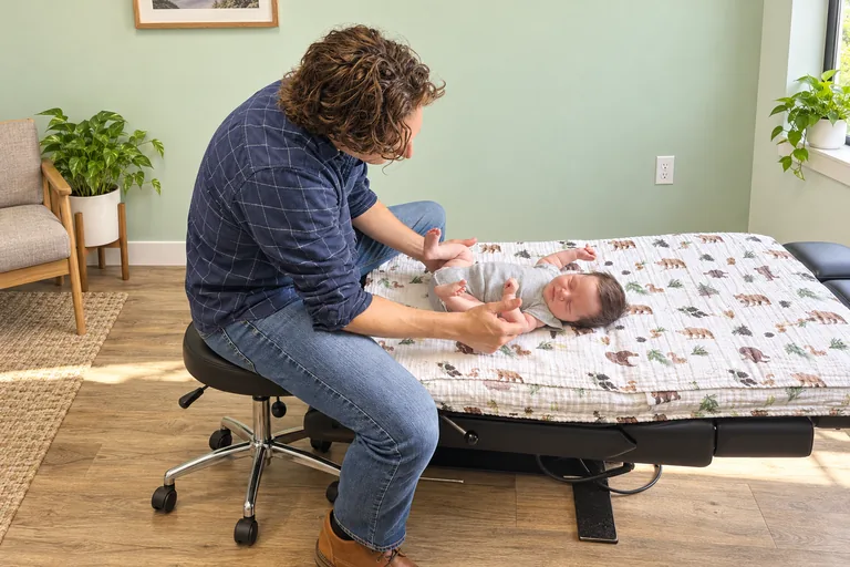 Dr. Zach Conner gently adjusting an infant on the table
