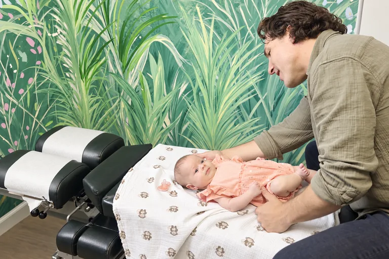 Dr. Zach Conner caring for a smiling baby